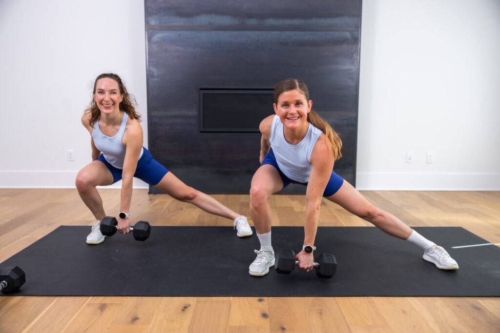 two women performing a lateral lunge in a glutes and hamstrings workout