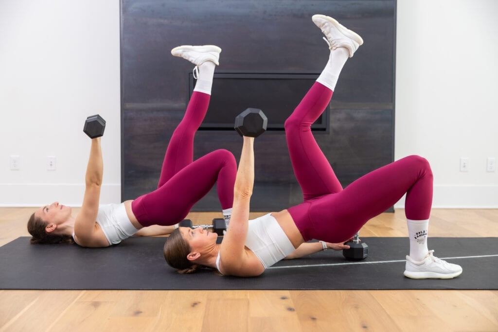 two women performing a chest press with dumbbells